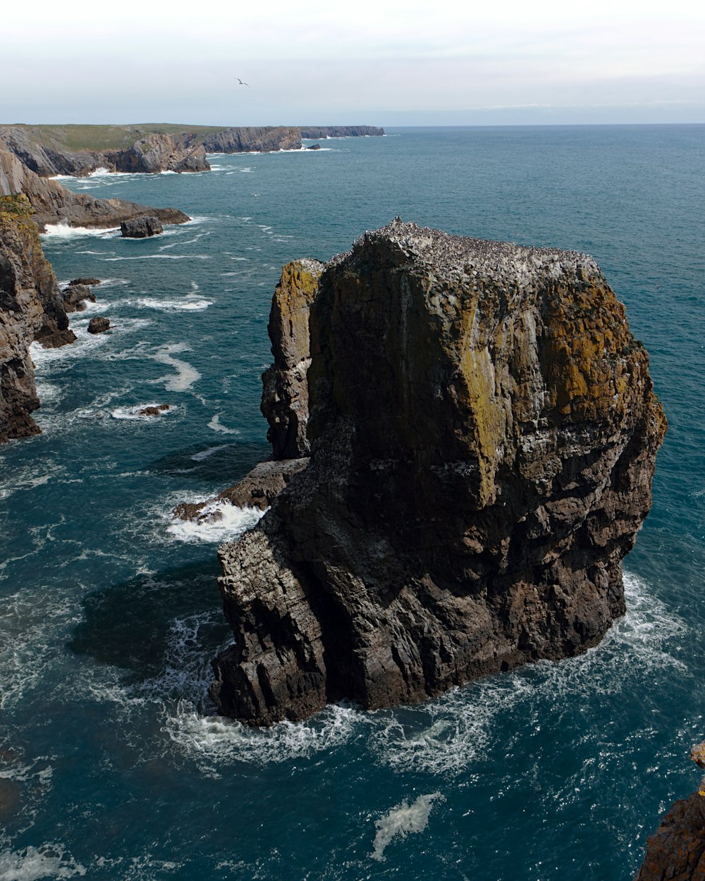 gray rock formation between sea