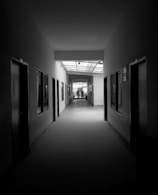 grayscale photography of pathway between rooms