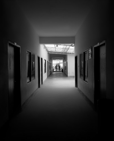 grayscale photography of pathway between rooms