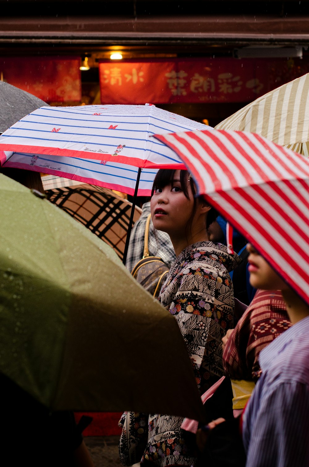 Frauen, die tagsüber einen roten Regenschirm benutzen