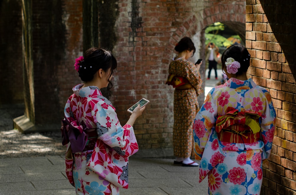 three women wearing kimono dresses during daytime