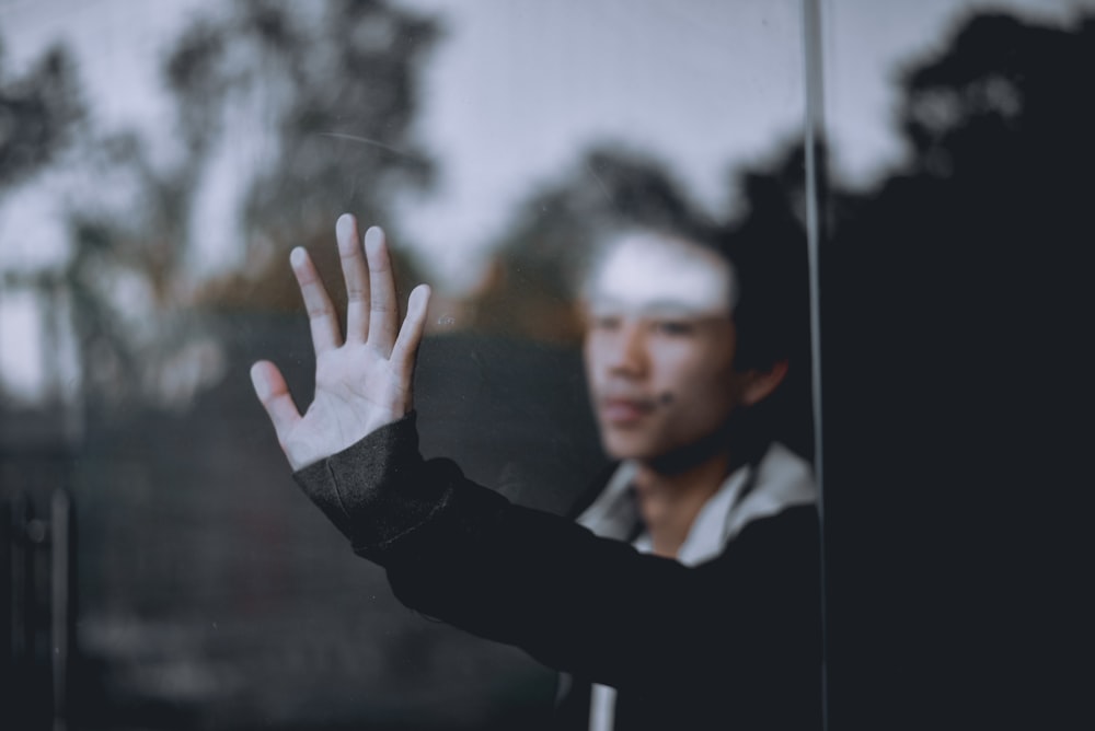 man holding clear glass wall