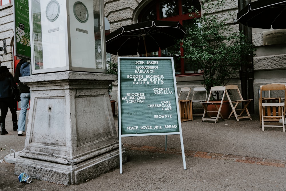 chalkboard easel sign beside pillar near chairs