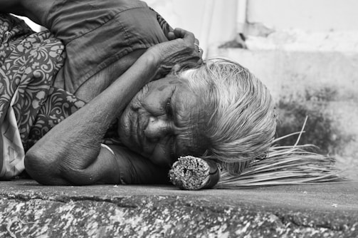 women sleeping on a concrete surface grey-scale photography