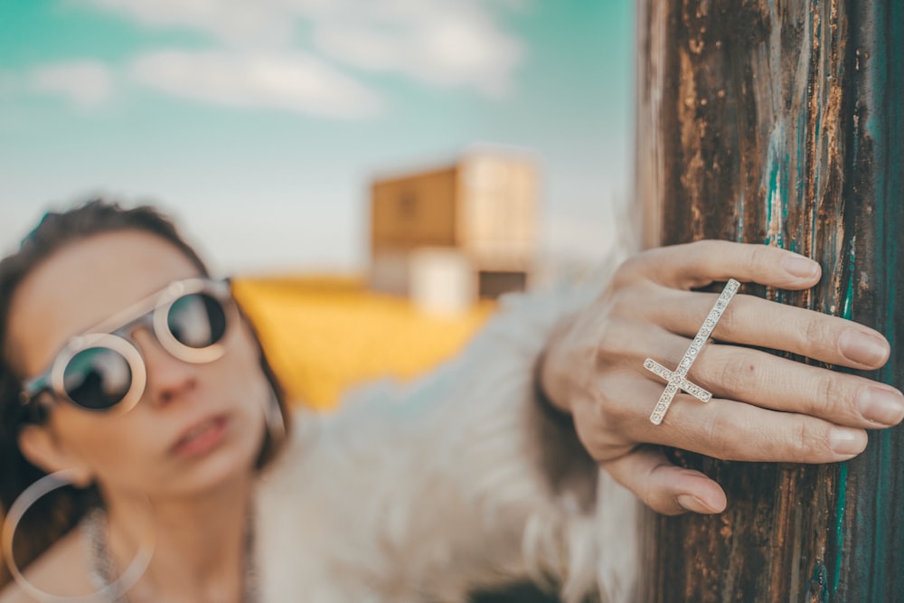 금색 십자가 반지를 착용 한 여성의 선택적 초점 사진