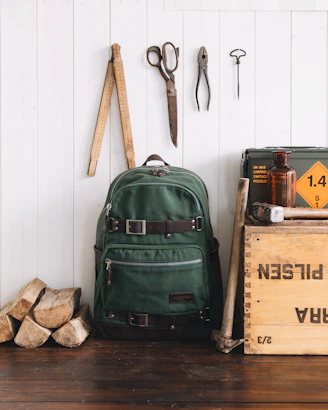 Colorful assortment of Vigepack backpacks displayed on wooden shelves with travel essentials around.