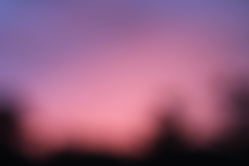 a blurry photo of the sky with trees in the background
