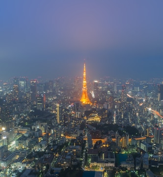 A vibrant cityscape at dusk with glowing telecom towers illuminating the skyline.