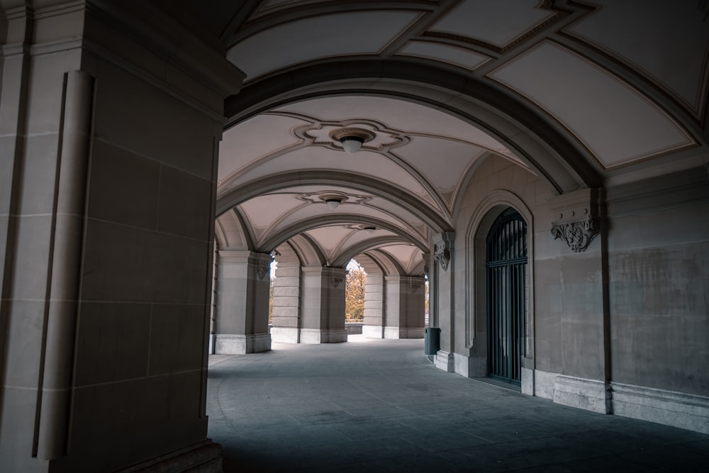 a hallway with arches and a clock on the wall