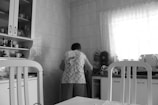grayscale photography of woman in kitchen