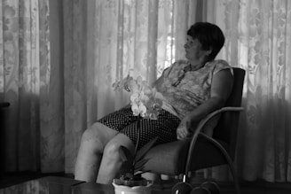 A serene scene of a senior woman settling comfortably into her elegant new living space with soft forest green and gold-beige accents.