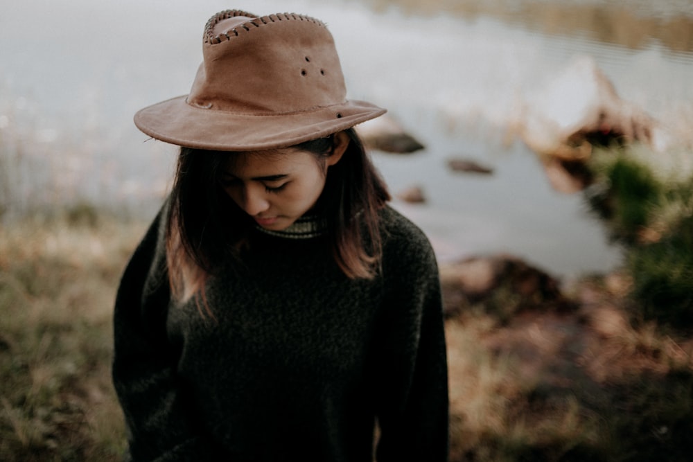 Mujer con suéter negro y sombrero de vaquero marrón