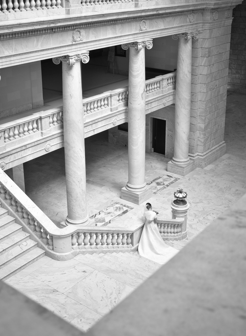 grayscale photography of woman near stairs