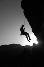 man hanging on cliff