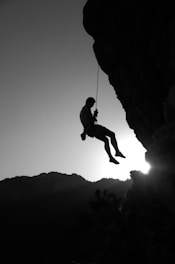 man hanging on cliff