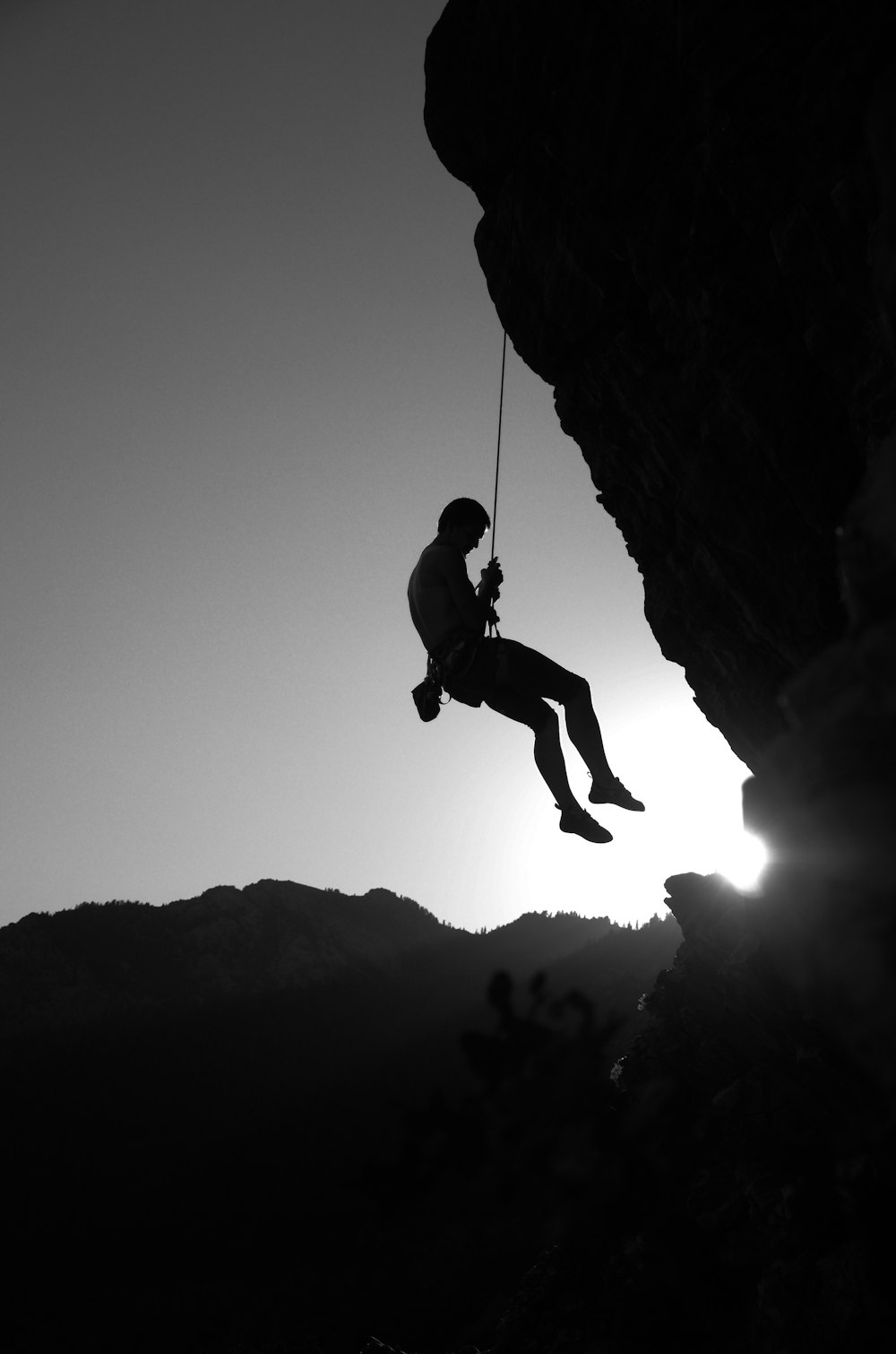 man hanging on cliff