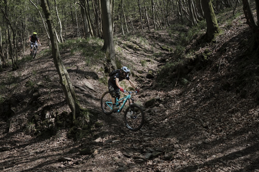 man riding blue mountain bike