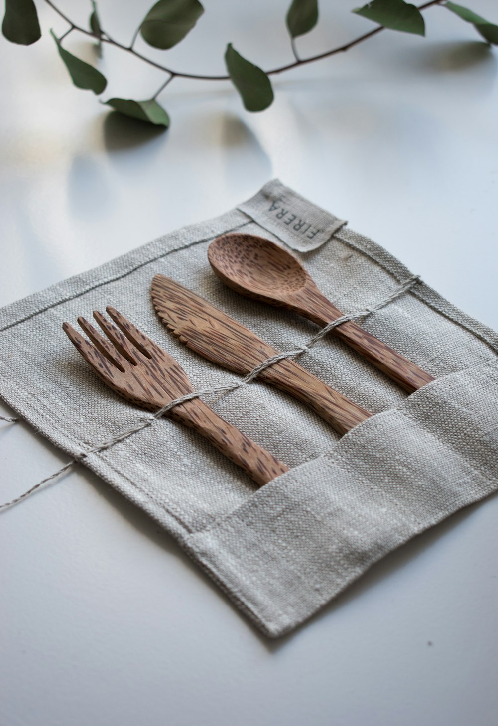 Forchetta, cucchiaio e coltello in legno marrone su tessuto