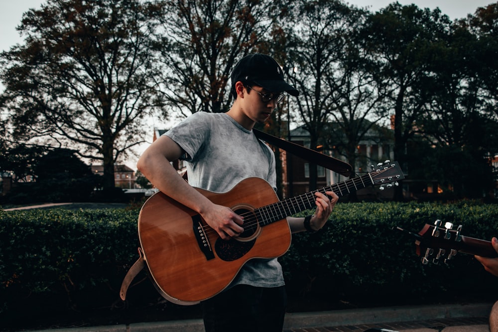 man carrying guitar while playing