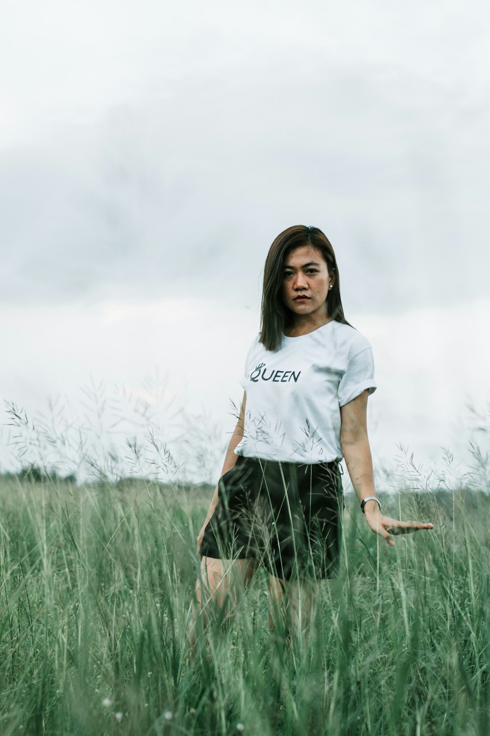woman in white shirt standing on grass field during daytime