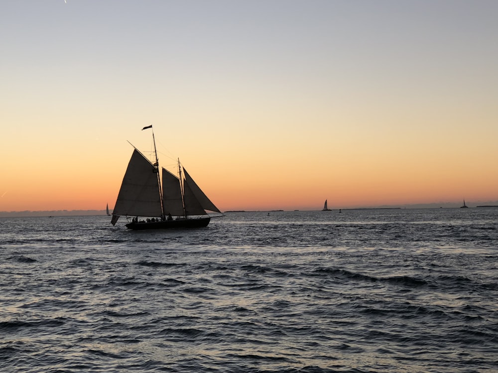 boat sailing on ocean during golden hour ]