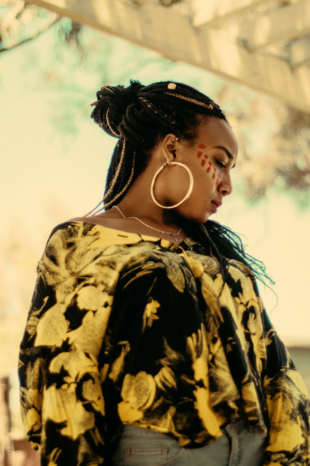 woman with face paint wearing hoop earring and scoop-neck blouse