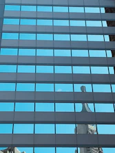 Close-up of sparkling clean commercial windows reflecting a bright blue sky.