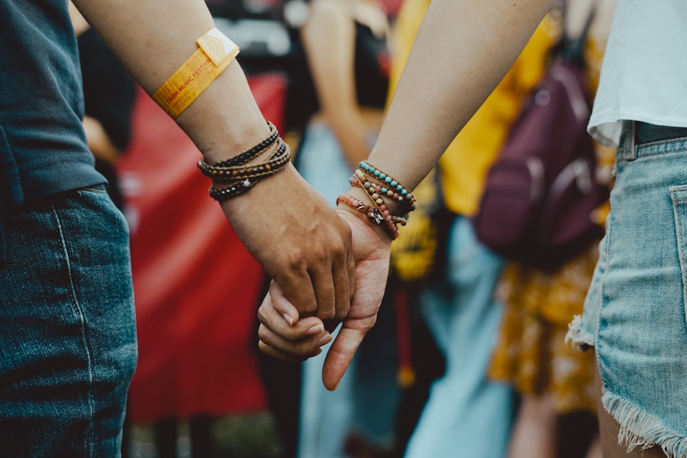 man and woman holding hands near people