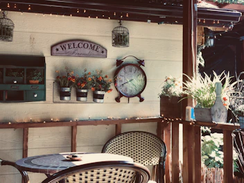 A charming farmhouse sign hanging above a welcoming patio bar set.