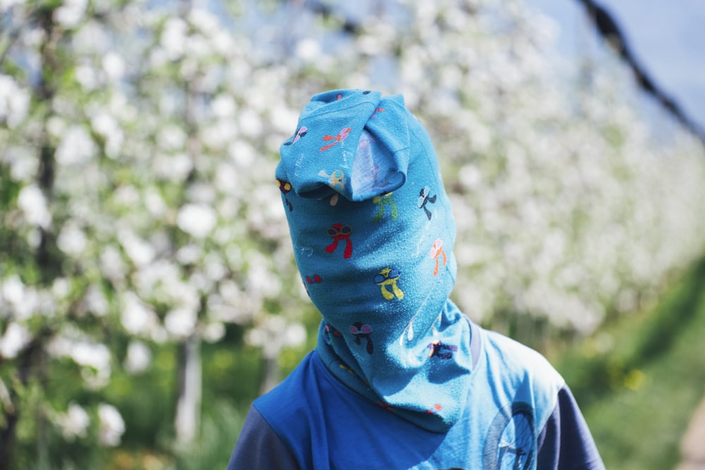 person in blue shirt with cover in face