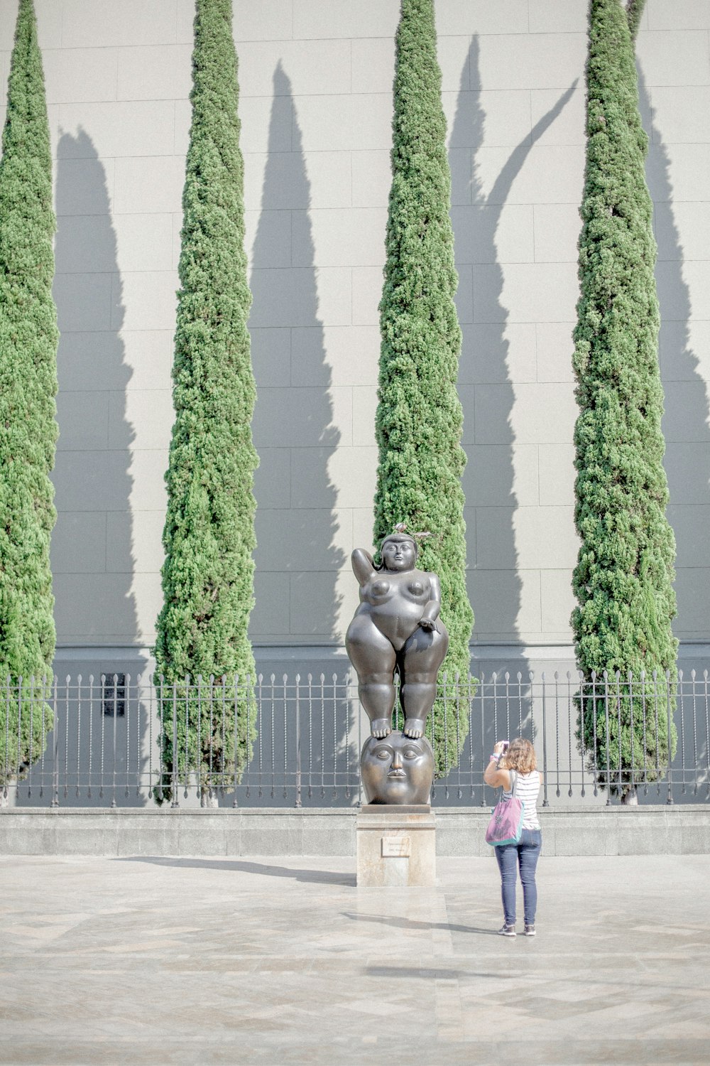 Mujer tomando foto de la estatua de la mujer desnuda