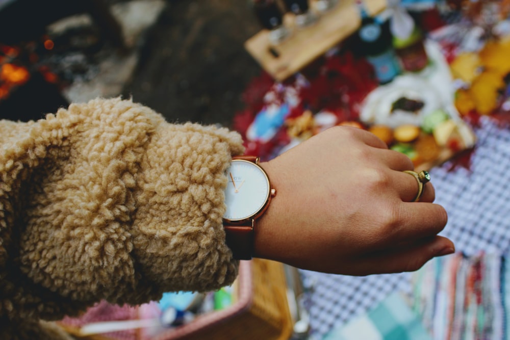 round gold-colored watch with band