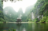 pagoda surrounded by body of water and mountains