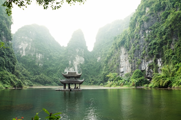 pagoda surrounded by body of water and mountains