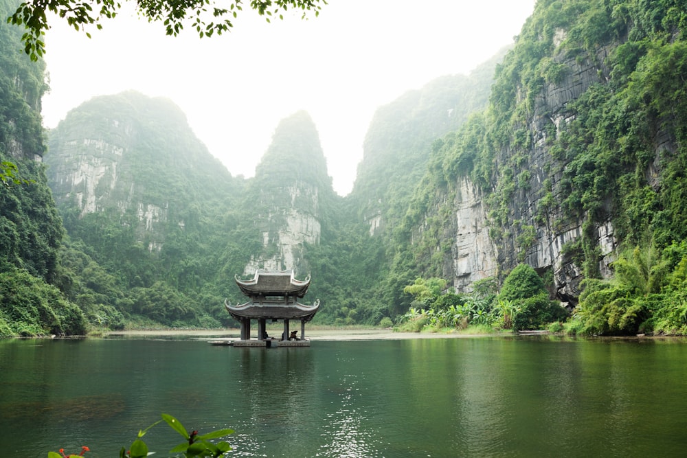 Pagoda rodeada de cuerpo de agua y montañas