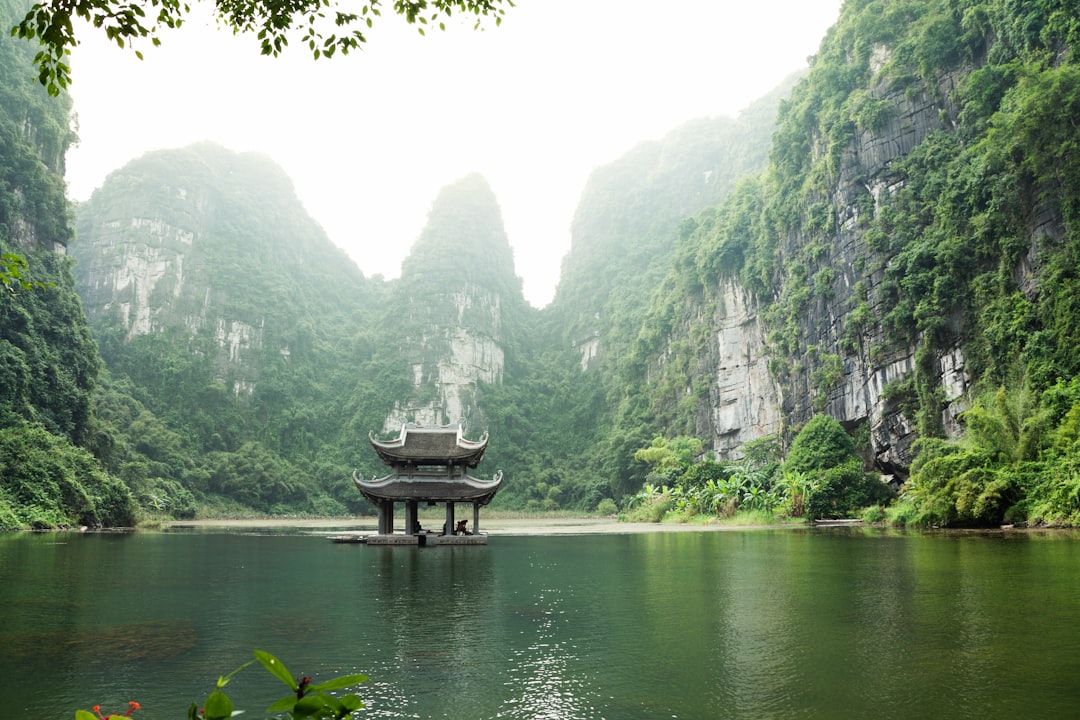 pagoda surrounded by body of water and mountains
