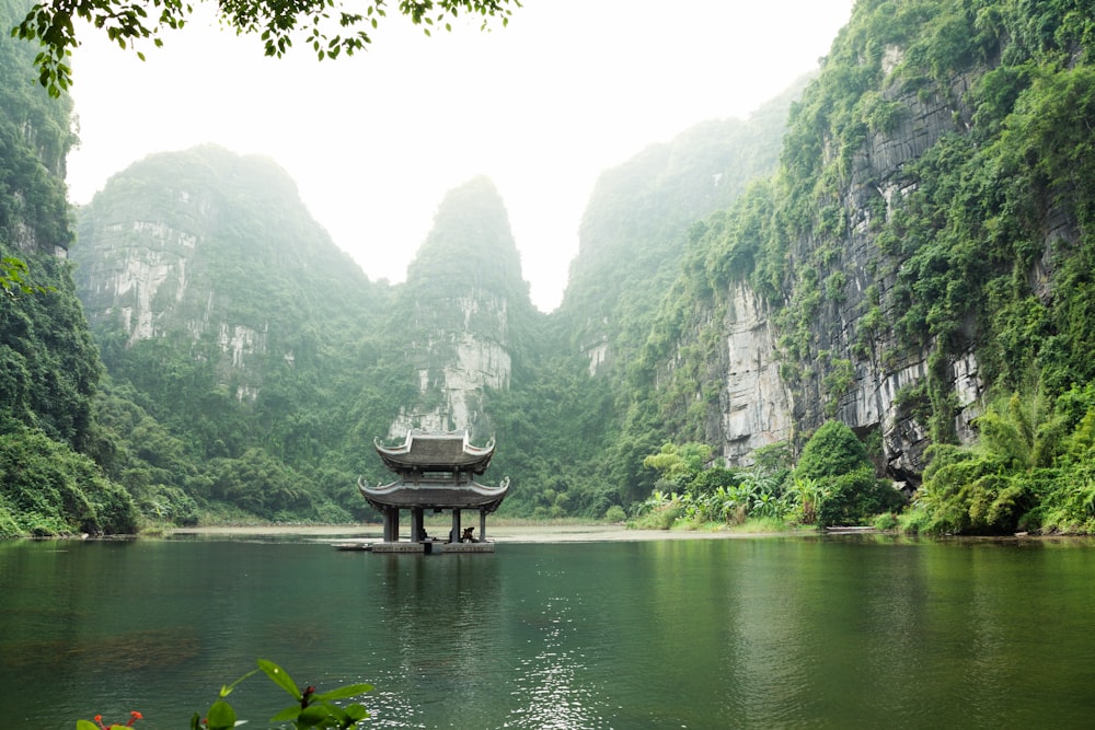 pagoda surrounded by body of water and mountains