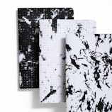 A set of elegant, custom-designed notebooks featuring clean lines and soft colors.