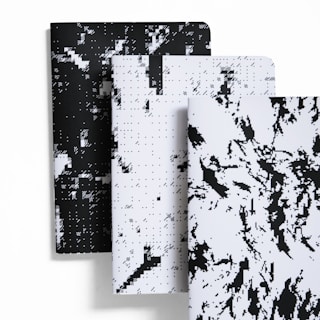 Stacked notebooks with minimalist covers featuring yellow details.