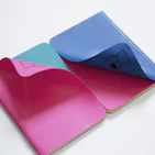 Brightly colored custom notebooks stacked neatly with creative cover designs.