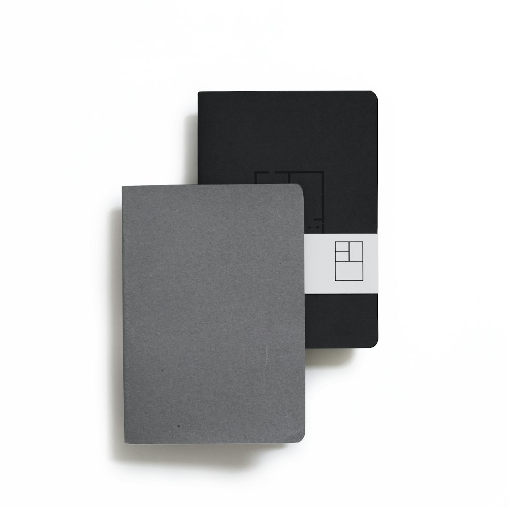 two black and gray book planners on white background