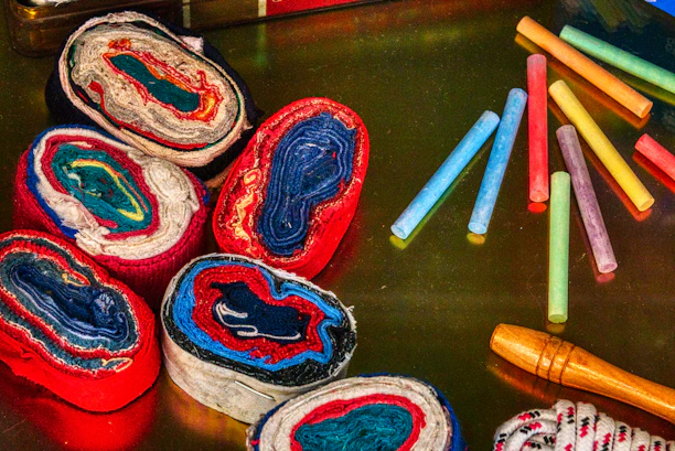 A vibrant silk painting kit laid out with brushes, dyes, and textured silk fabric.
