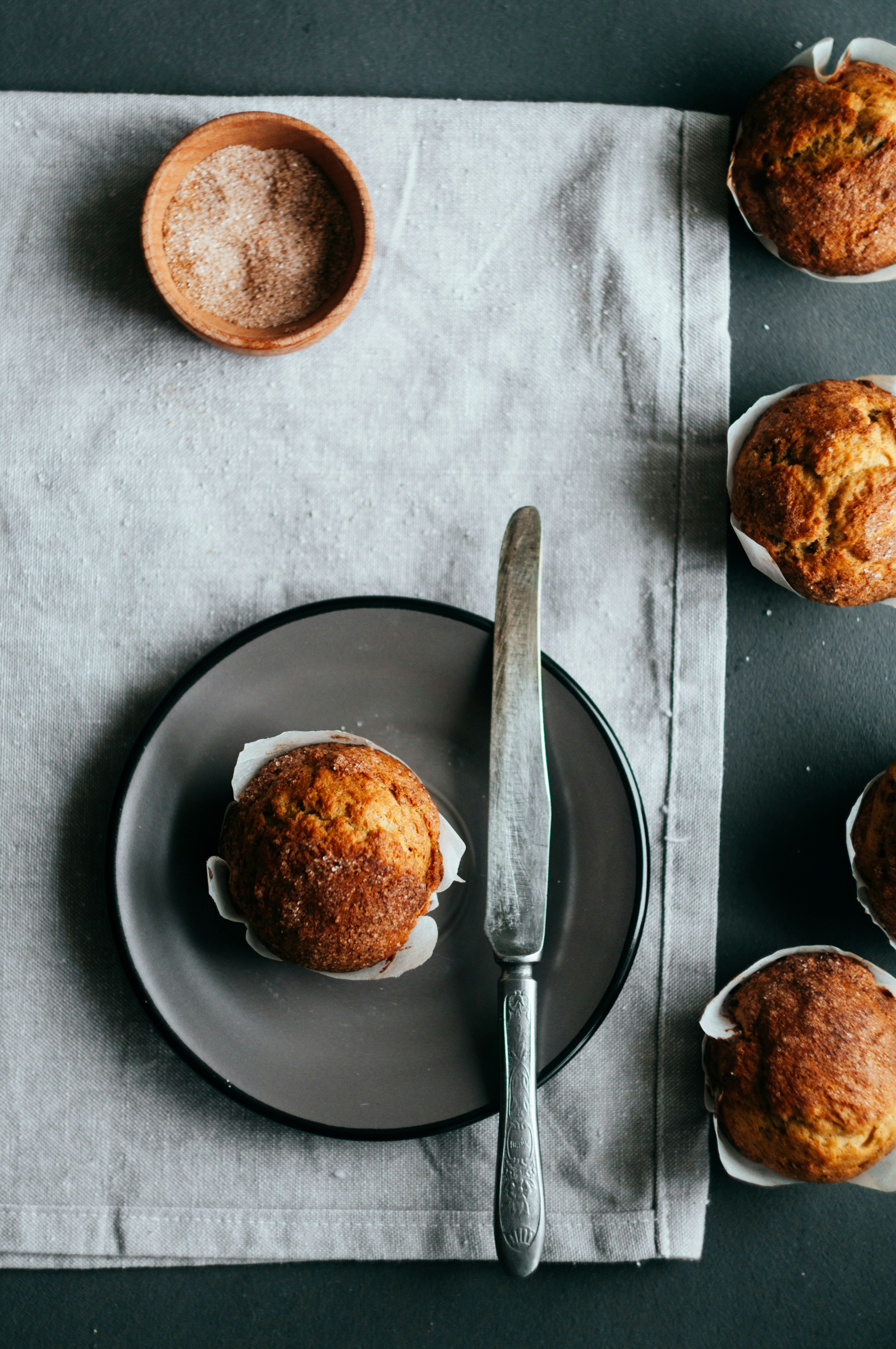 muffin on plate beside knife