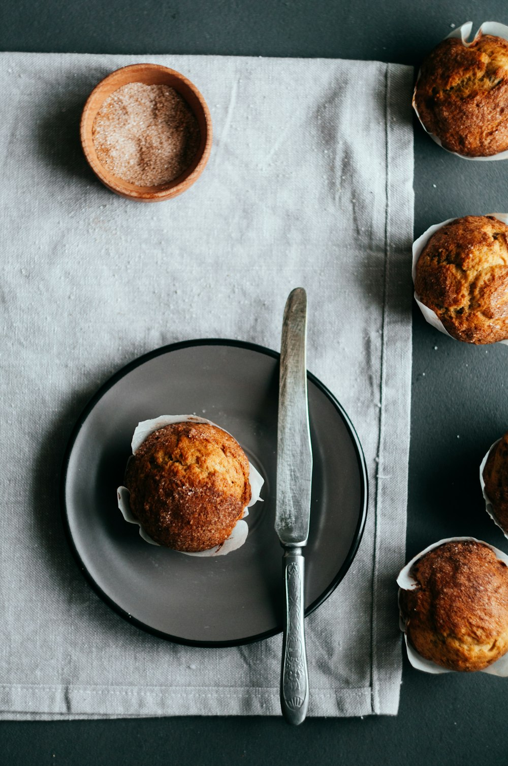 muffin on plate beside knife