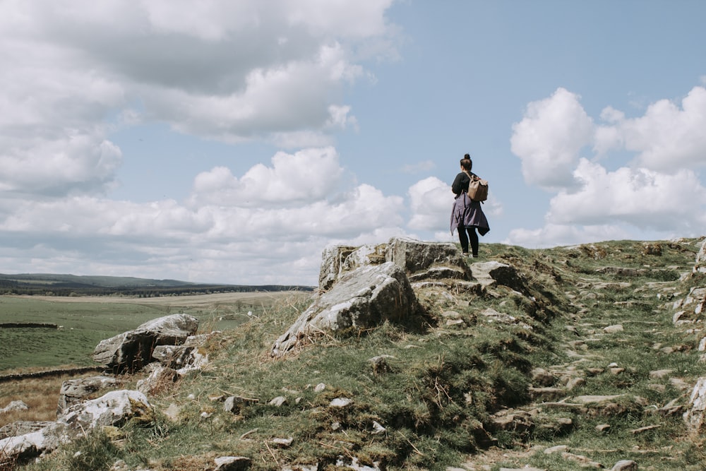 girl standing on rock outdoor during daytime