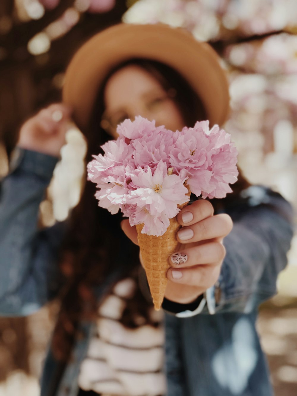 woman holding cone with flowers selective focus photography