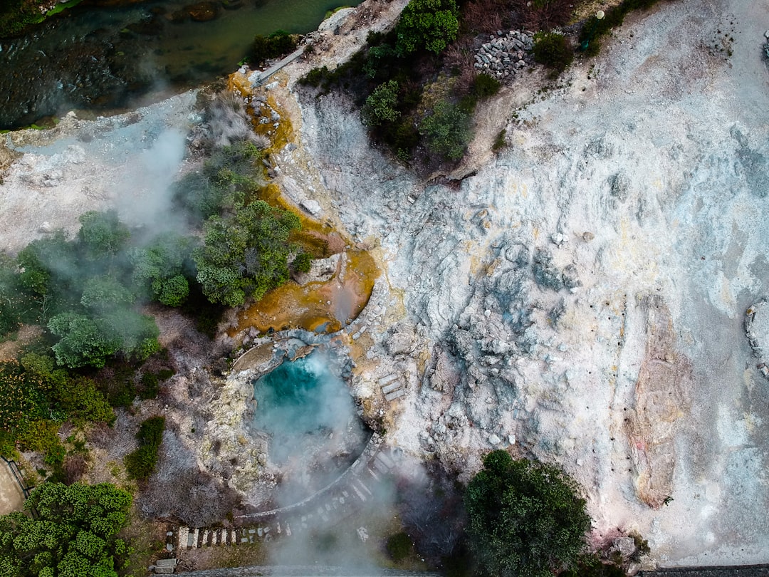 aerial photo of body of water, This photo was taken in Furnas, São Miguel. This area is knows for its geothermal activity, the village center is full of holes with boiling water and if you touch the ground everything is warm.<p></figure>On top of that the colors of the earth make you feel like you