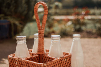 Small glass bottles of lavender vinegar lined up on a rustic wooden table