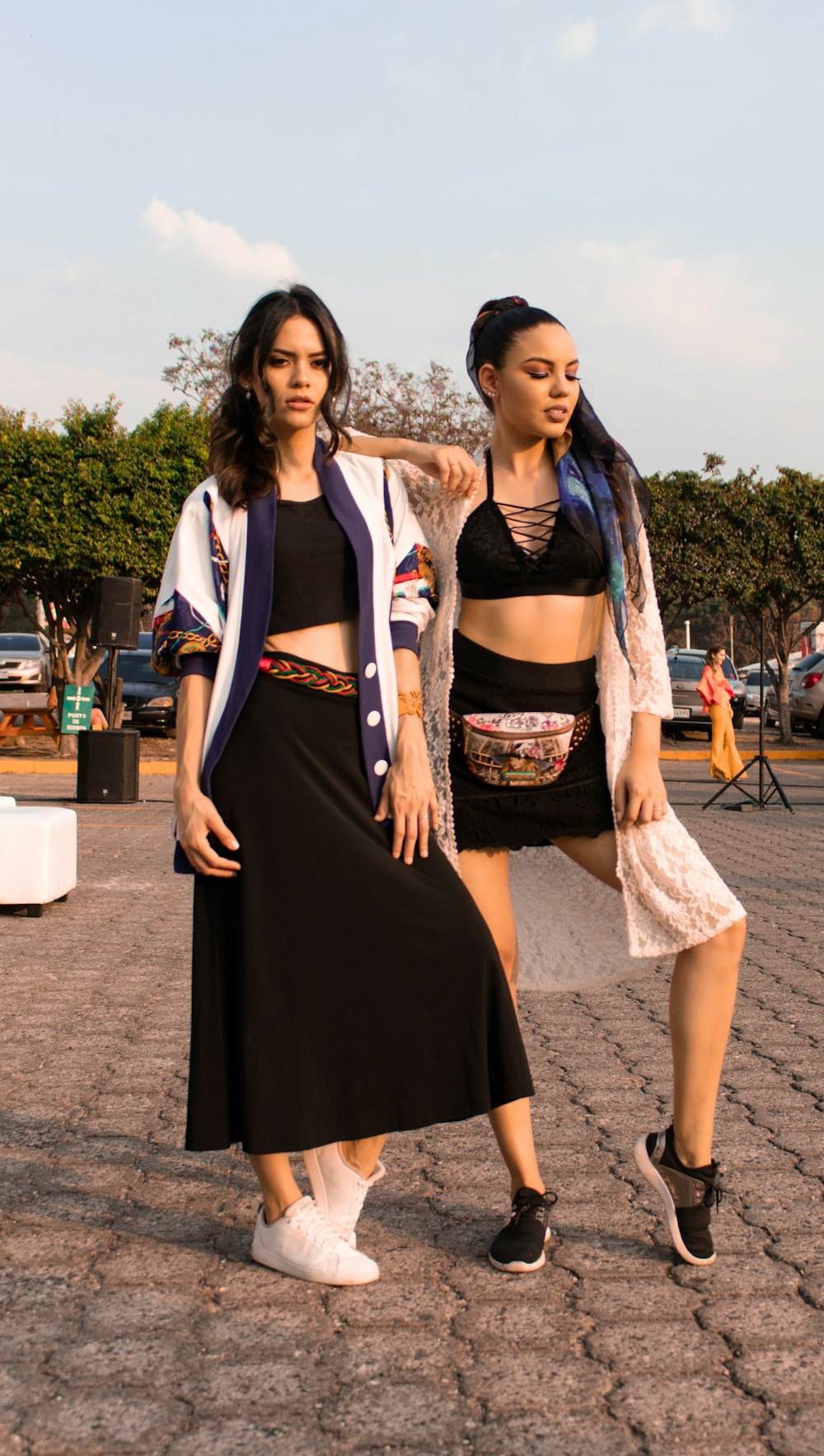 two women standing and posing near trees