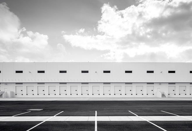 A long white industrial building with open desert nearby, similar to the large warehouse projects taking shape at Apex